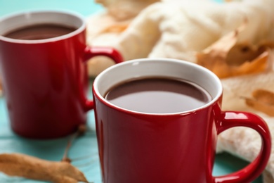 Photo of Cups of hot drink on table, closeup. Cozy autumn atmosphere