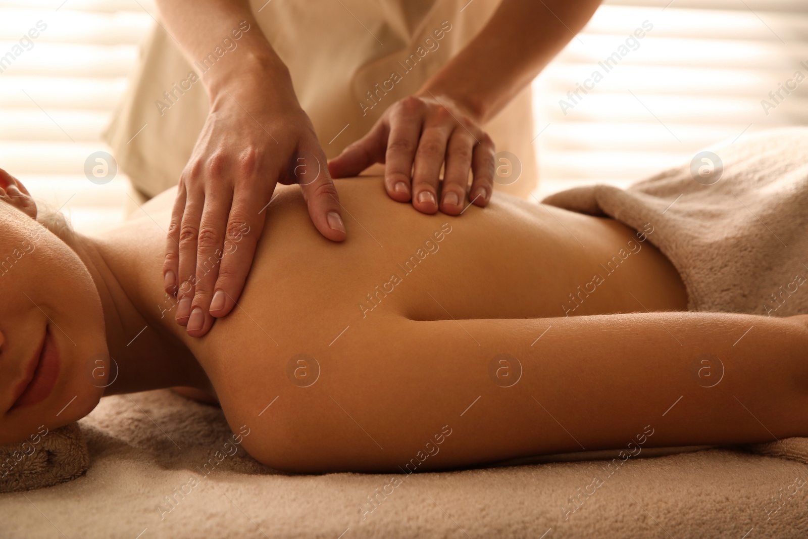 Photo of Young woman receiving back massage in spa salon, closeup