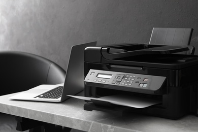 New modern printer and laptop on grey table indoors