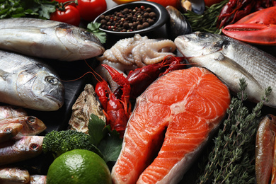 Fresh fish and different seafood on table, closeup