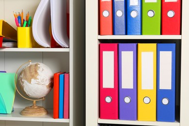 Photo of Colorful binder office folders and other stationery on shelving unit