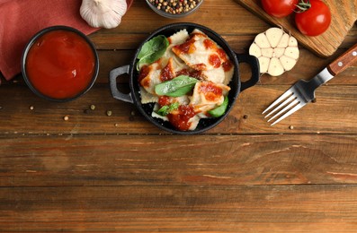 Photo of Tasty ravioli with tomato sauce served on wooden table, flat lay. Space for text