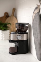 Photo of Modern coffee grinder on counter in kitchen