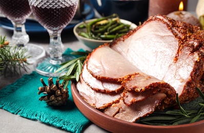 Delicious Christmas ham served with garnish on table