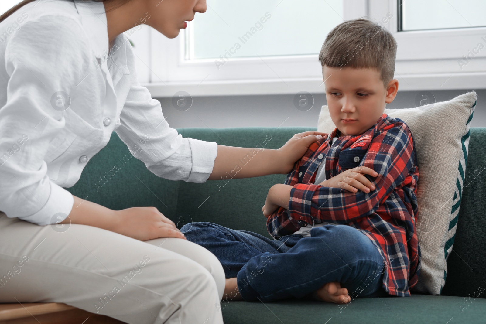 Photo of Psychologist working with unhappy little boy in office. Mental health problems