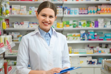 Photo of Professional pharmacist with clipboard in modern drugstore