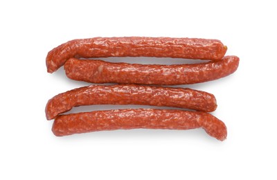 Photo of Thin dry smoked sausages isolated on white, top view