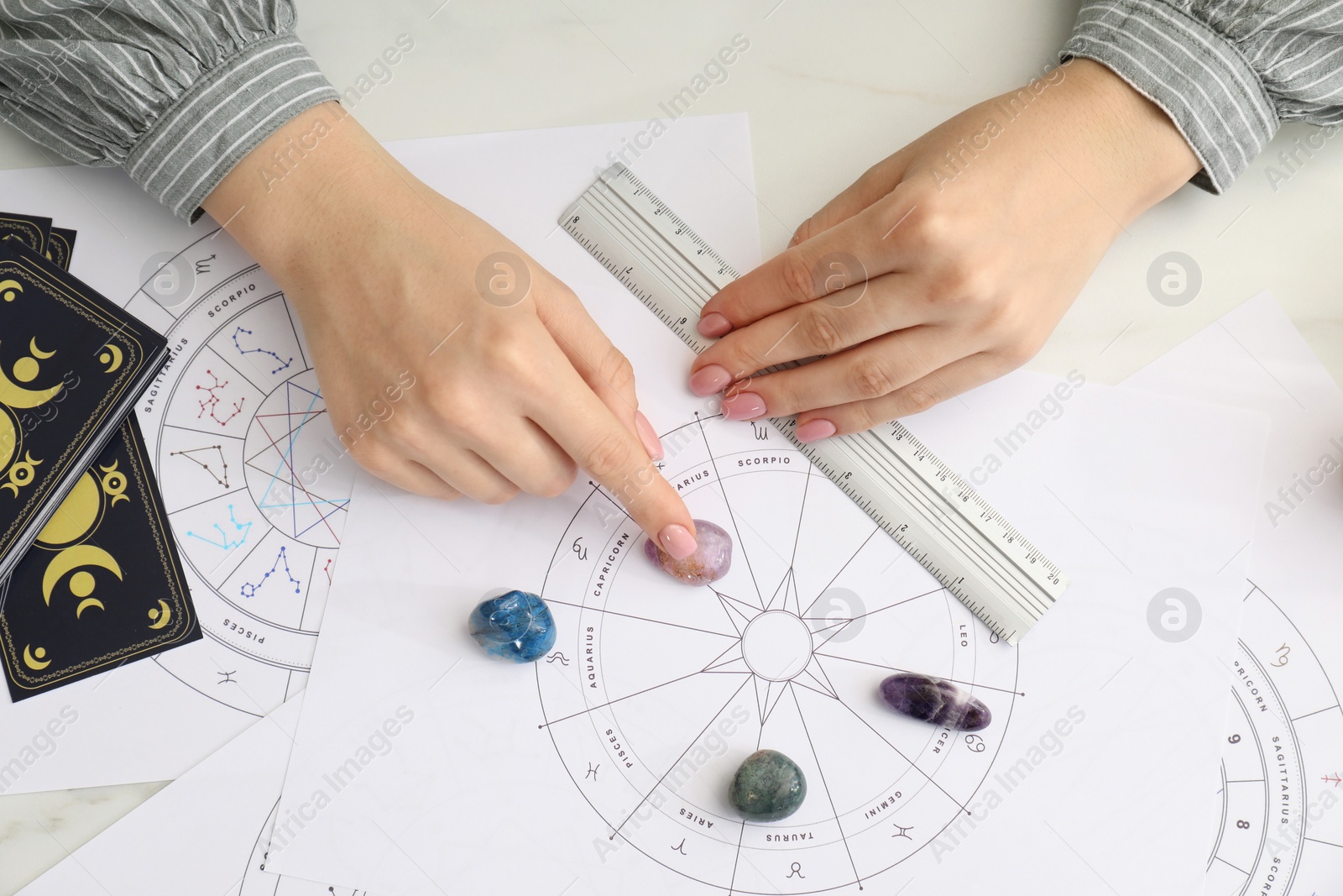 Photo of Astrologer using zodiac wheel for fate forecast at table, top view. Fortune telling