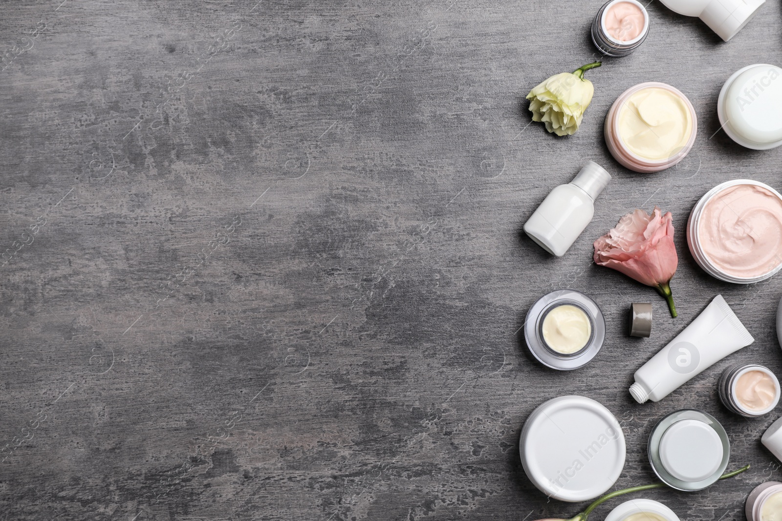 Photo of Flat lay composition with hand cream jars and space for text on gray background