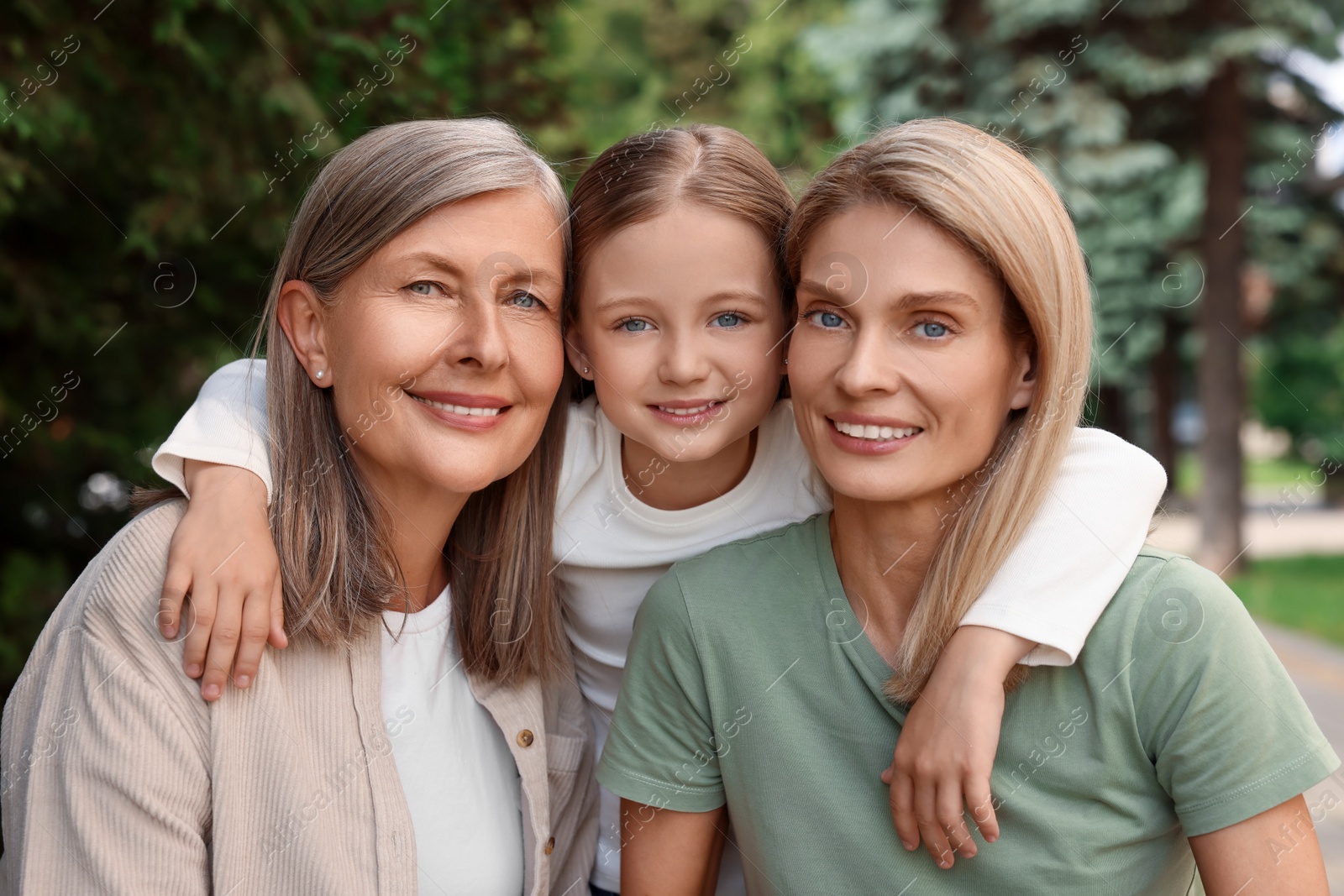 Photo of Three generations. Happy grandmother, her daughter and granddaughter outdoors