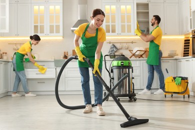 Team of professional janitors working in kitchen