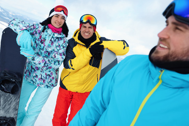 Photo of Group of friends with equipment in snowy mountains. Winter vacation