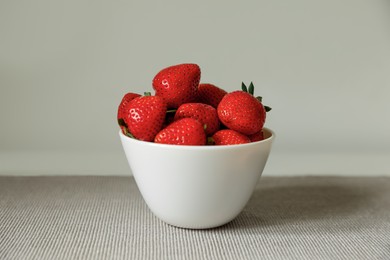 Photo of Fresh juicy strawberries in bowl on table