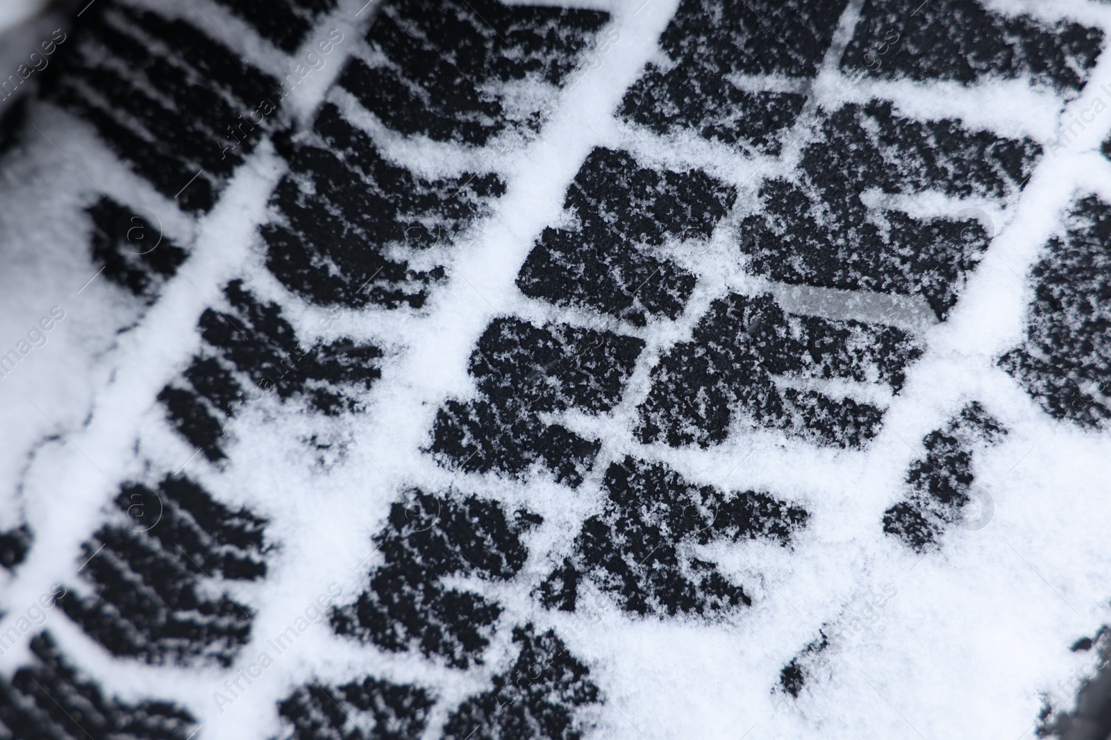 Photo of Winter tire covered with snow, closeup view