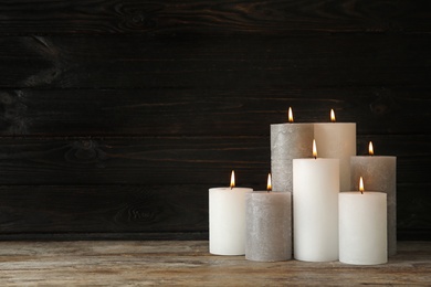 Alight wax candles on table. Space for text