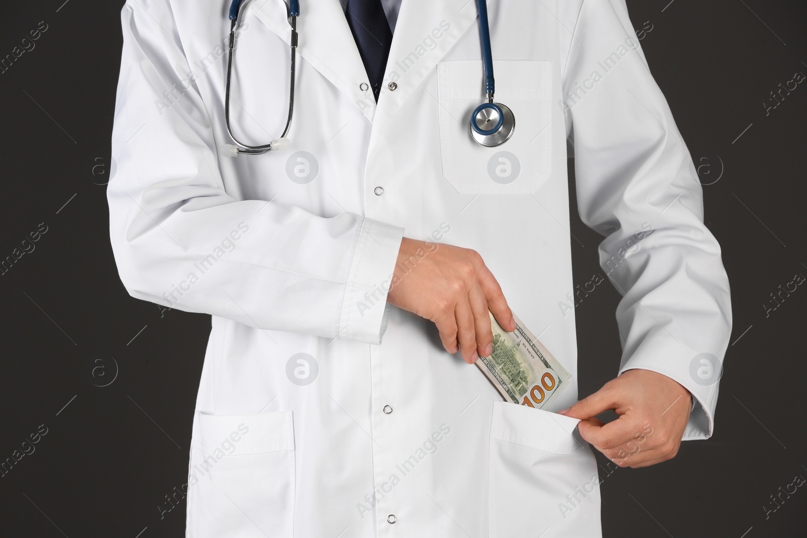 Photo of Doctor putting bribe into pocket on black background, closeup. Corruption in medicine