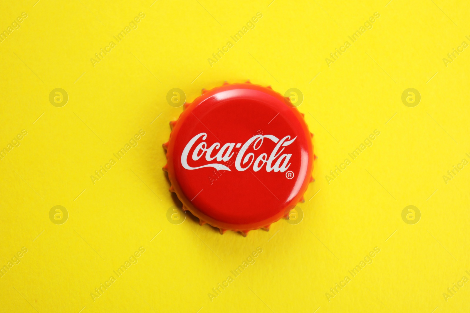 Photo of MYKOLAIV, UKRAINE - NOVEMBER 15, 2018: Coca Cola lid on color background, top view