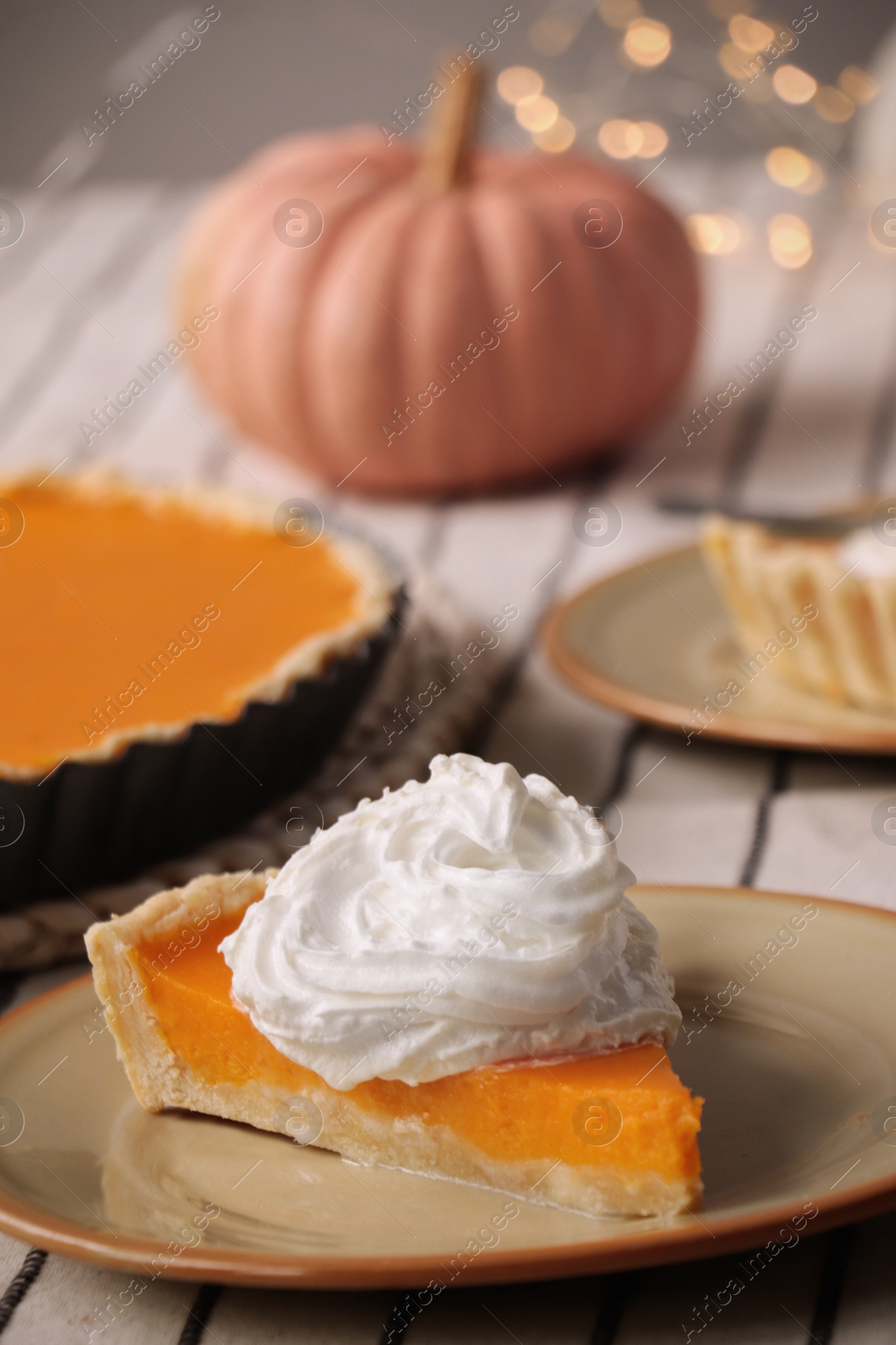 Photo of Piece of fresh homemade pumpkin pie with whipped cream on table