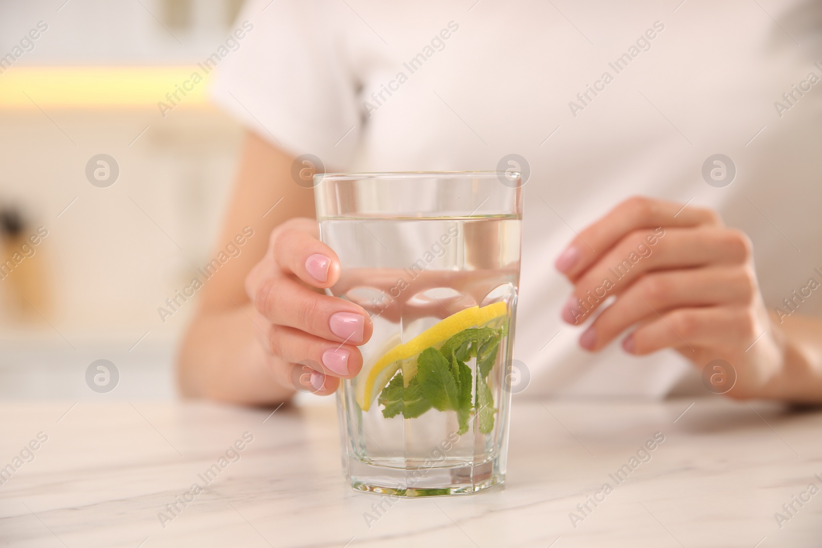 Photo of Young woman with glass of fresh lemonade at home, closeup