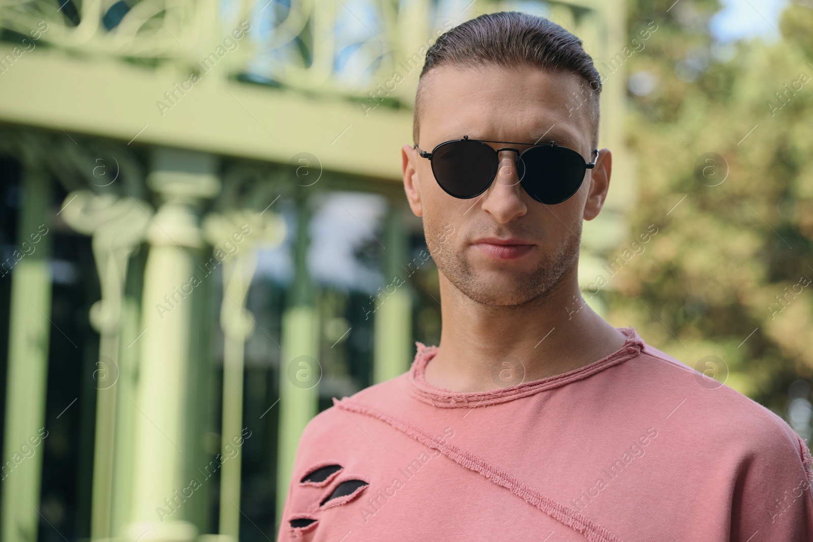 Photo of Portrait of handsome man in sunglasses outdoors, space for text