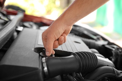 Photo of Mechanic opening engine oil filler cap, closeup