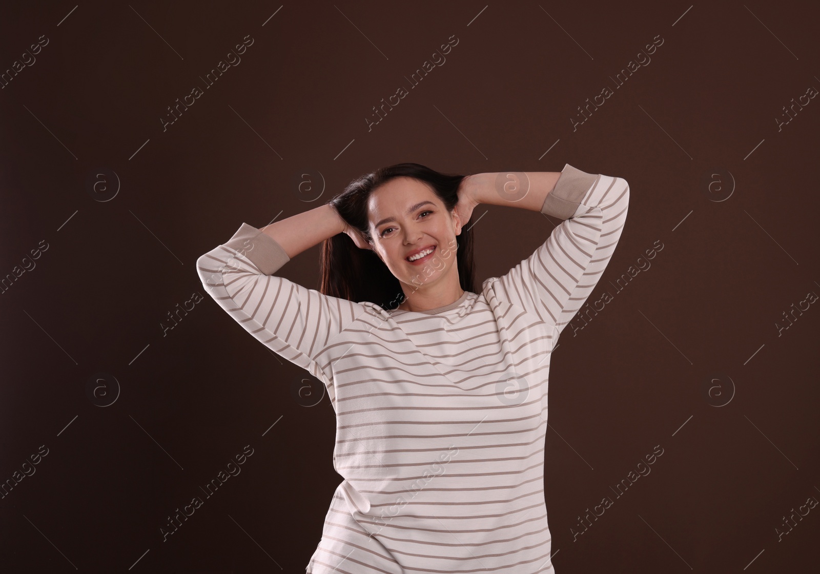 Photo of Beautiful overweight woman with charming smile on brown background