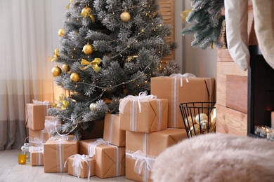 Stylish room interior with beautiful Christmas tree and gift boxes