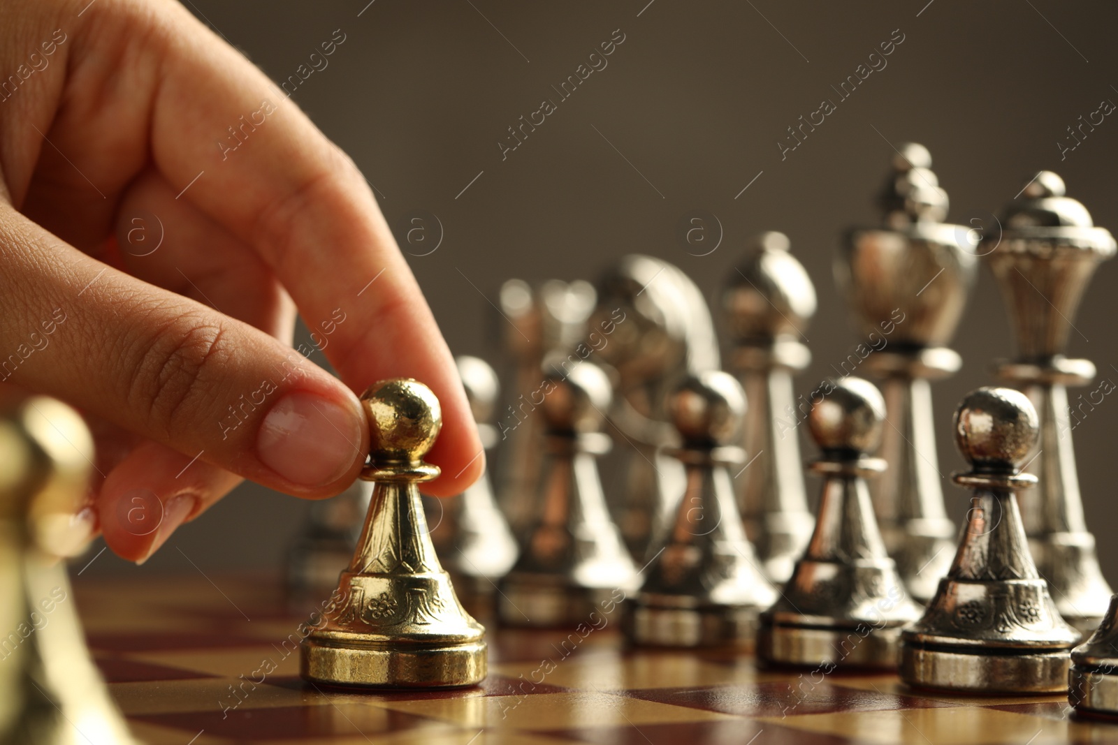 Photo of Woman moving chess piece on board, closeup