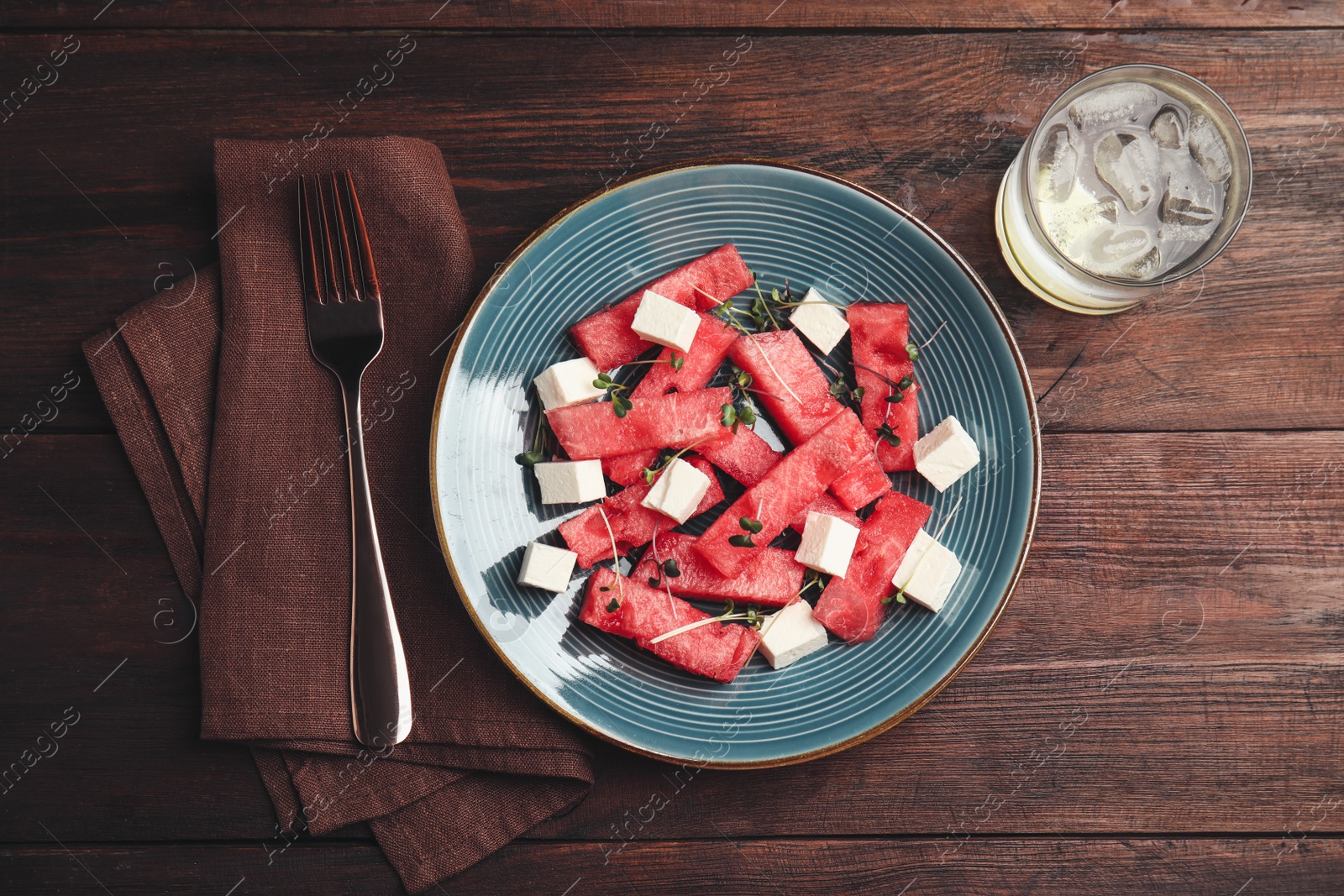 Photo of Delicious salad with watermelon and feta cheese on wooden table, flat lay