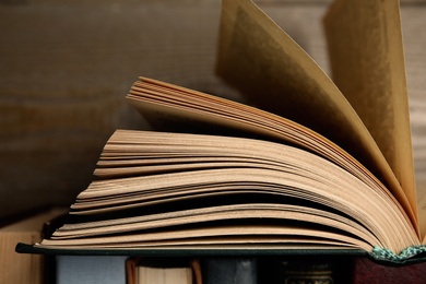 Open hardcover book near wooden background, closeup