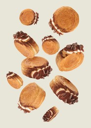 Image of Delicious round croissants in air on light background. Puff pastry