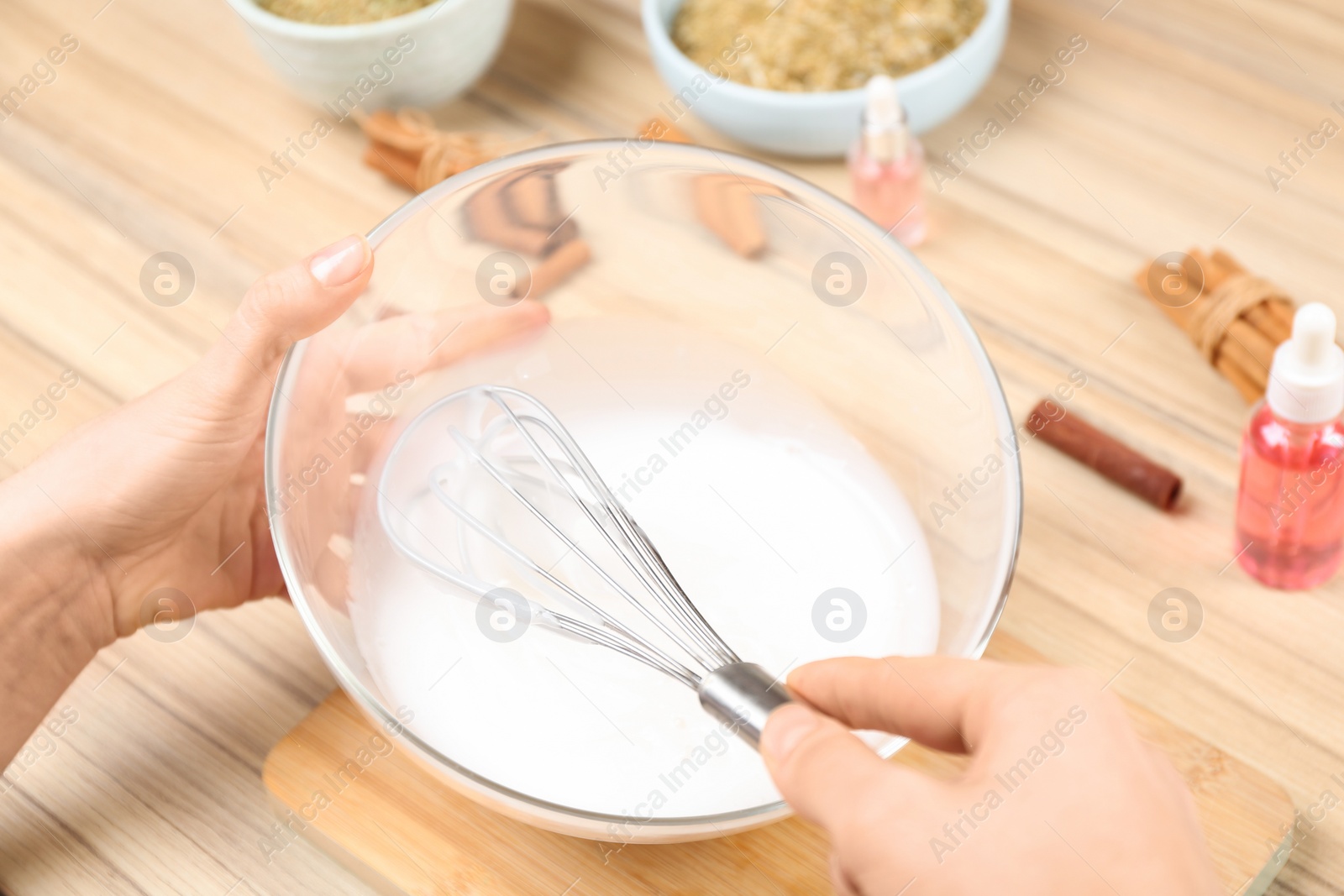 Photo of Woman making natural handmade soap at wooden table, closeup