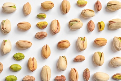 Photo of Composition with organic pistachio nuts on white background, top view