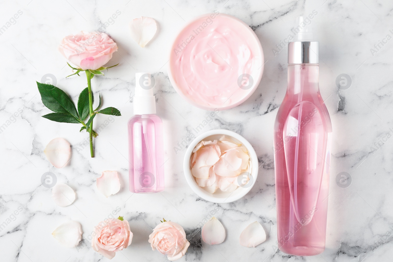 Photo of Flat lay composition with rose essential oil on marble table