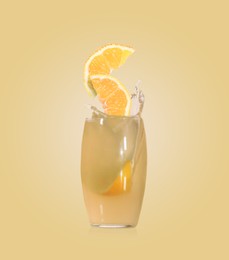 Image of Splashing freshly made lemon juice on pale yellow background. Slices of citrus fruit falling into glass