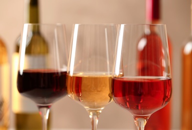 Photo of Glasses of different wines against blurred background, closeup