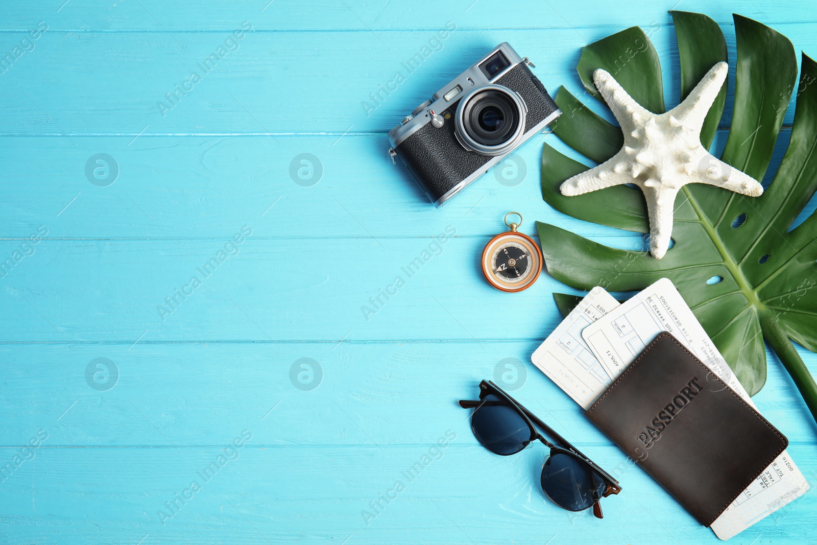 Photo of Flat lay composition with passport and camera on color wooden background, space for text