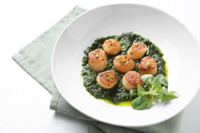 Photo of Delicious fried scallops with tasty sauce and corn salad in bowl on white table, closeup