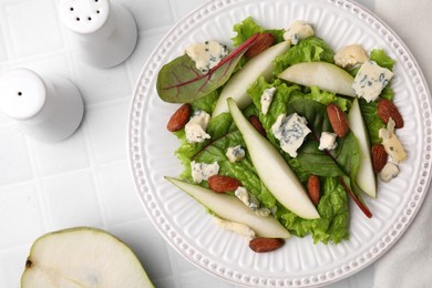 Photo of Delicious pear salad on white tiled table, flat lay