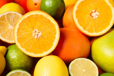 Different fresh citrus fruits as background, closeup