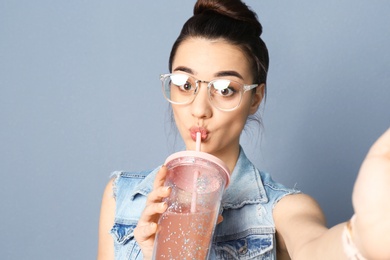 Photo of Young beautiful woman taking selfie against grey background