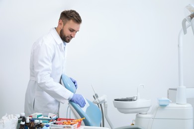 Photo of Professional dentist in white coat cleaning workplace  indoors
