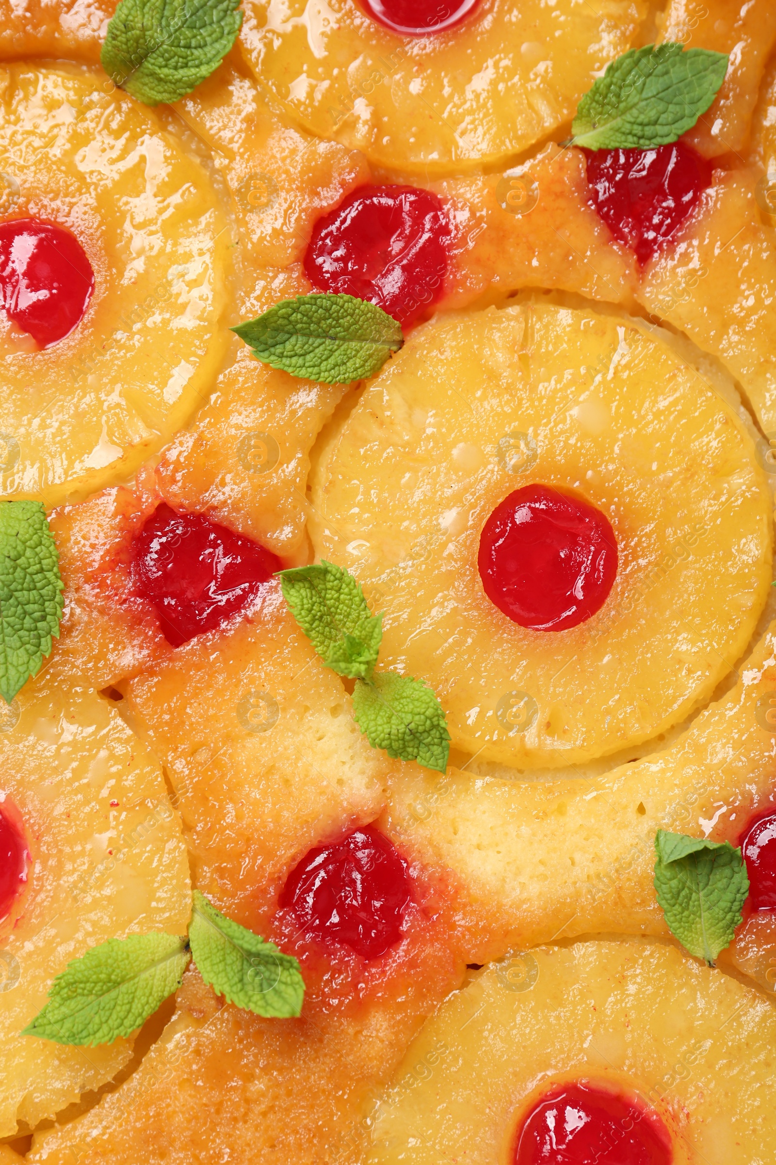 Photo of Tasty pineapple cake with cherries and mint as background, top view