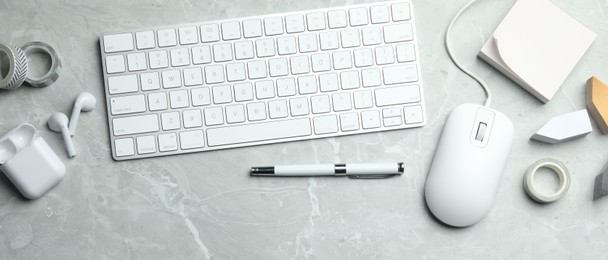 Photo of Flat lay composition with wired computer mouse and keyboard on light grey marble table. Space for text