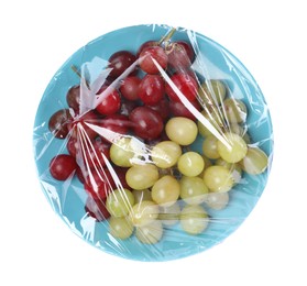 Photo of Plate of fresh grapes wrapped with transparent plastic stretch film isolated on white, top view