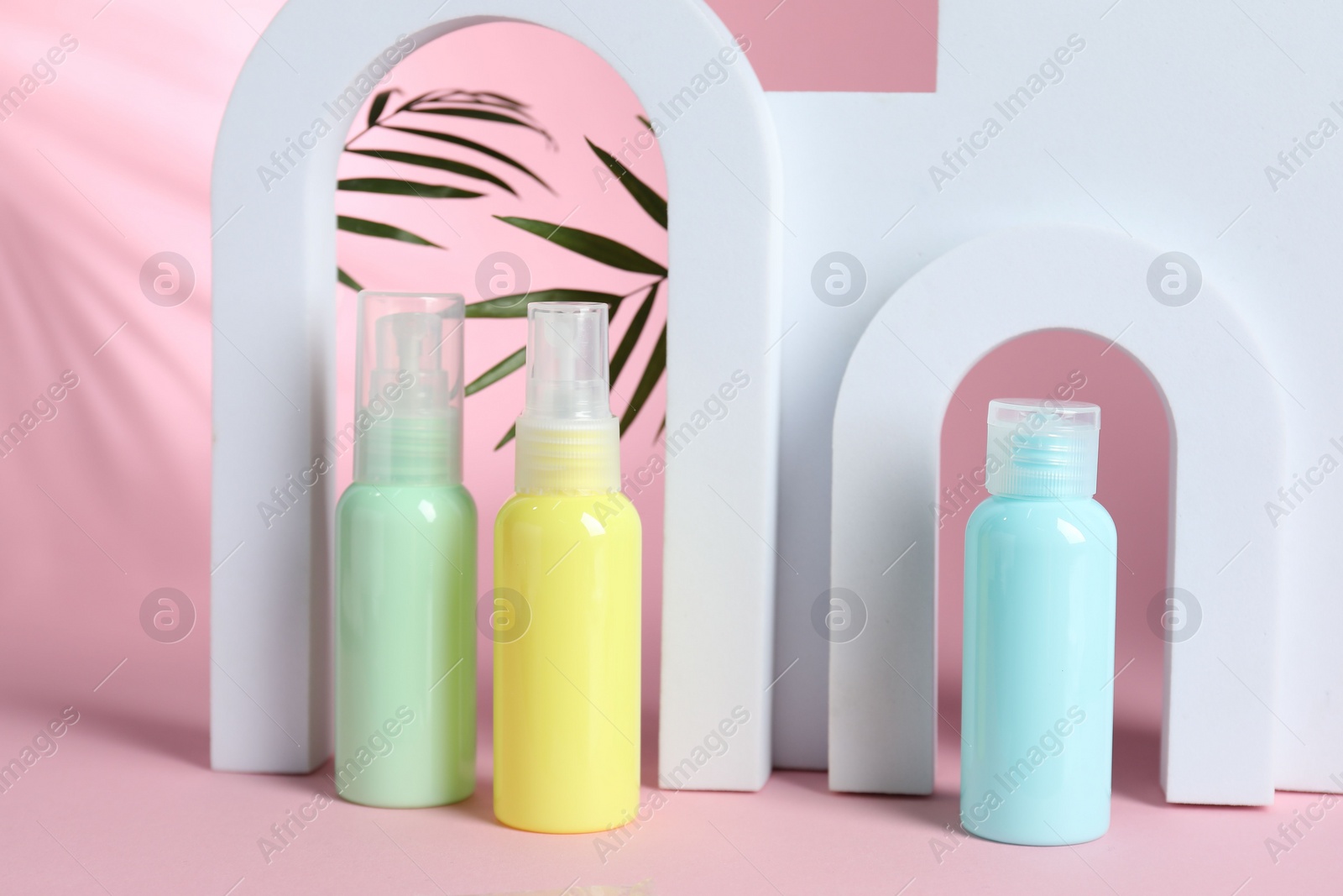 Photo of Cosmetic travel kit and geometric figures on pink background. Bath accessories