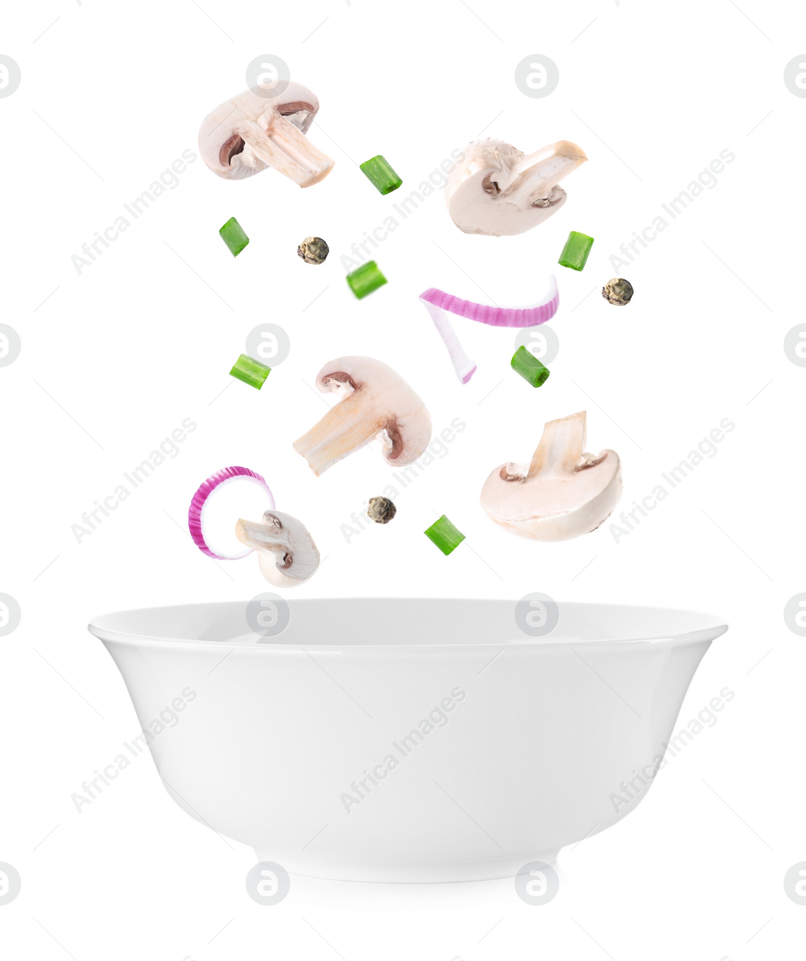 Image of Fresh mushrooms and other ingredients falling into bowl on white background