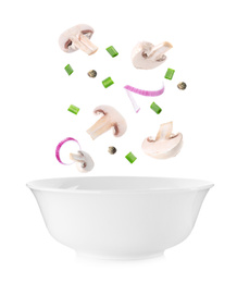 Image of Fresh mushrooms and other ingredients falling into bowl on white background