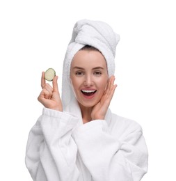 Beautiful woman in bathrobe with piece of cucumber on white background