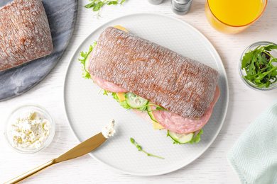 Photo of Tasty sandwich with ham served on white wooden table, flat lay